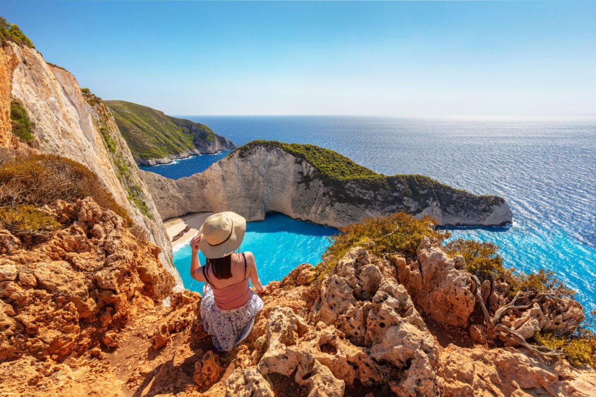 Woman looking over Navagio Beach, Zakynthos, Greece